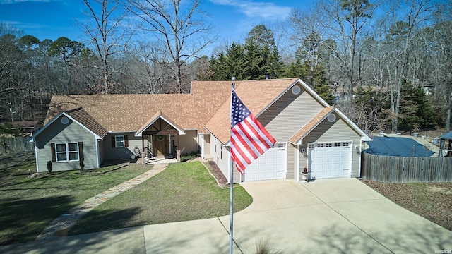 ranch-style home with an attached garage, fence, driveway, roof with shingles, and a front lawn