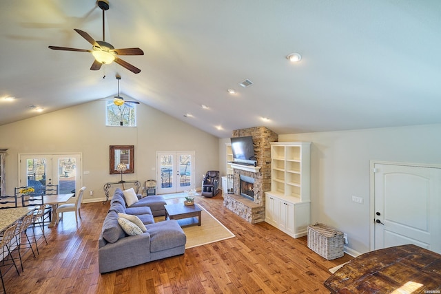 living room featuring french doors, visible vents, plenty of natural light, and a stone fireplace