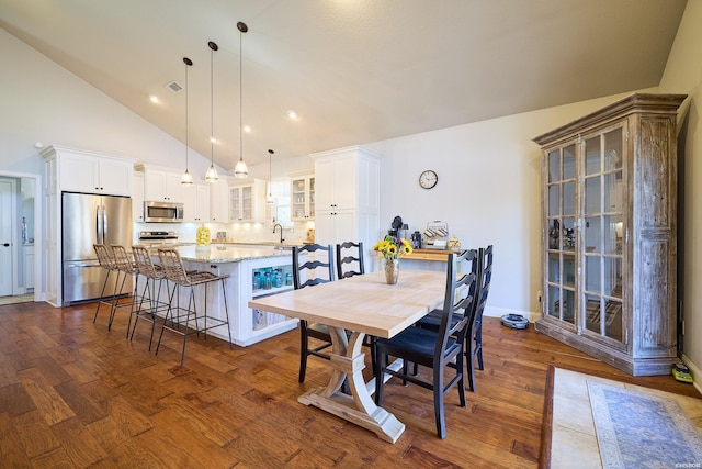 dining room with high vaulted ceiling, dark wood-type flooring, and baseboards