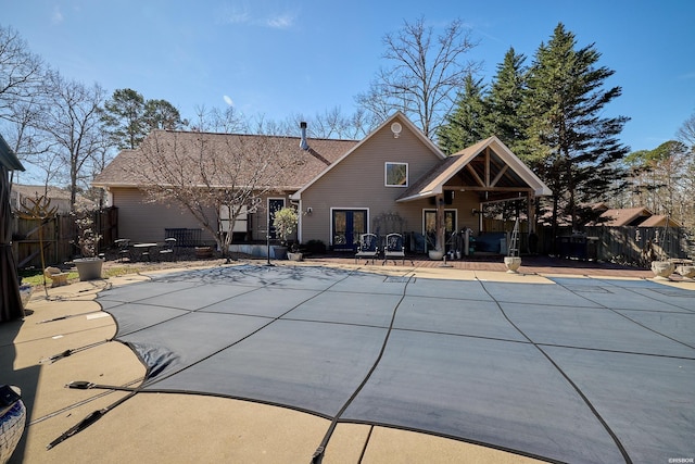 view of swimming pool featuring a patio, french doors, fence, and a fenced in pool