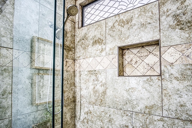 interior details featuring tiled shower