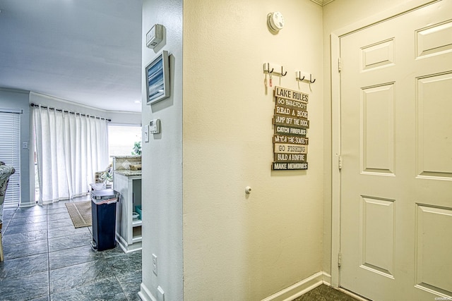 hall with baseboards and crown molding