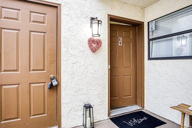 doorway to property featuring stucco siding