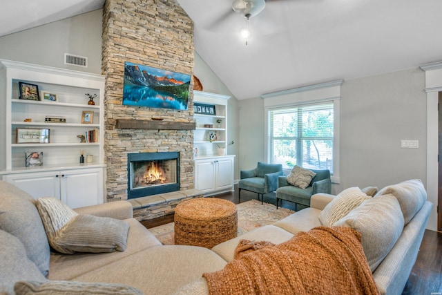 living area featuring high vaulted ceiling, a stone fireplace, wood finished floors, visible vents, and a ceiling fan