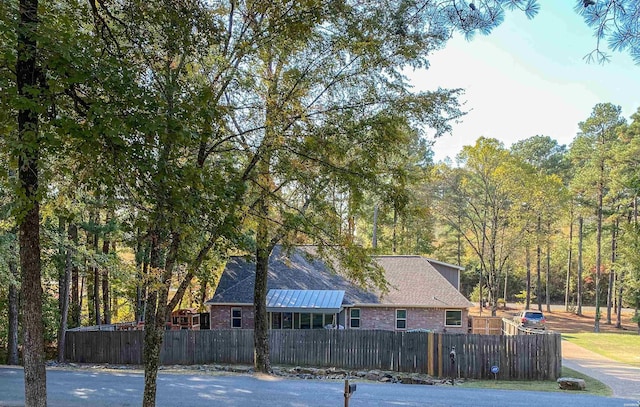 view of side of property with a fenced front yard and brick siding