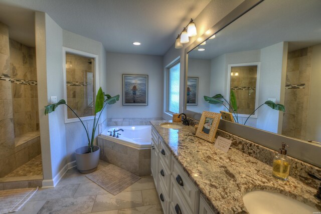 bathroom with double vanity, walk in shower, a sink, and a bath