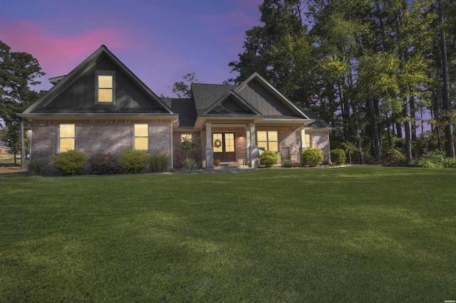 craftsman-style house with brick siding and a yard