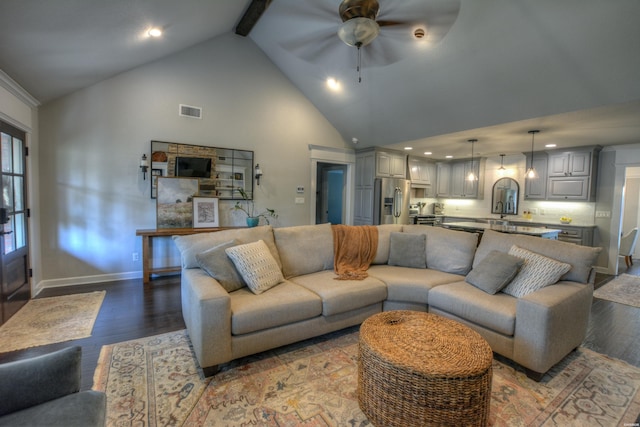 living area featuring high vaulted ceiling, visible vents, baseboards, and wood finished floors