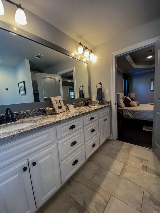 bathroom with marble finish floor, connected bathroom, a sink, and double vanity