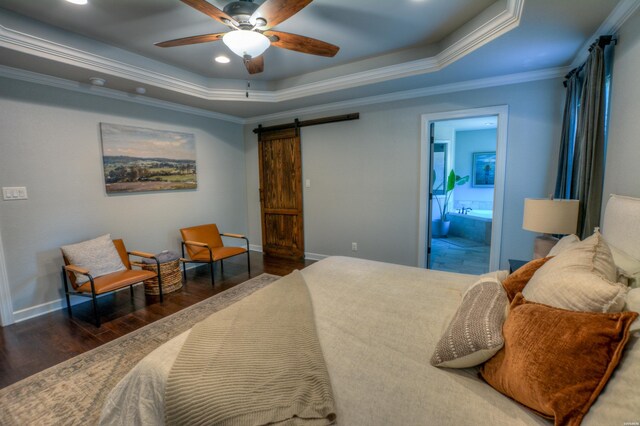 bedroom with dark wood-style flooring, crown molding, a raised ceiling, a barn door, and baseboards