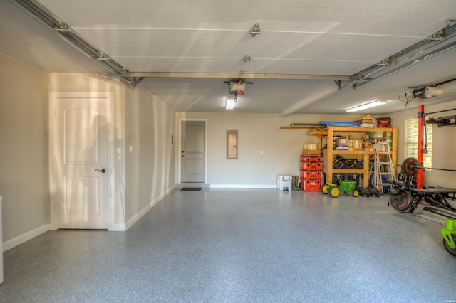 garage featuring a garage door opener and baseboards