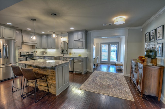 kitchen with stainless steel appliances, visible vents, gray cabinets, a center island, and pendant lighting