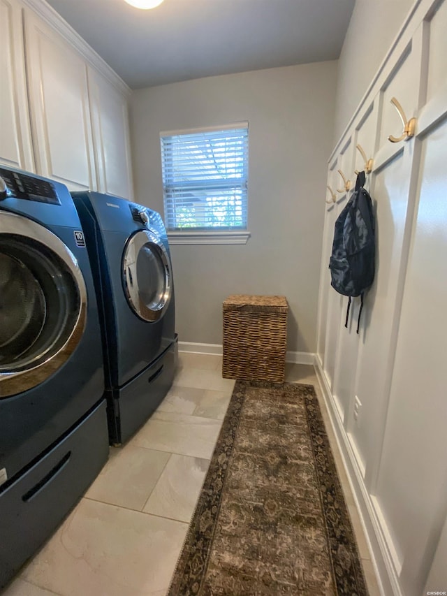 laundry area with washing machine and clothes dryer, cabinet space, and baseboards