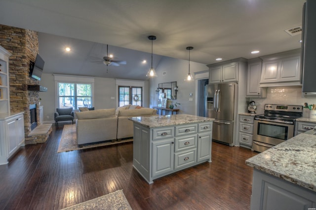 kitchen with visible vents, appliances with stainless steel finishes, open floor plan, decorative light fixtures, and a center island