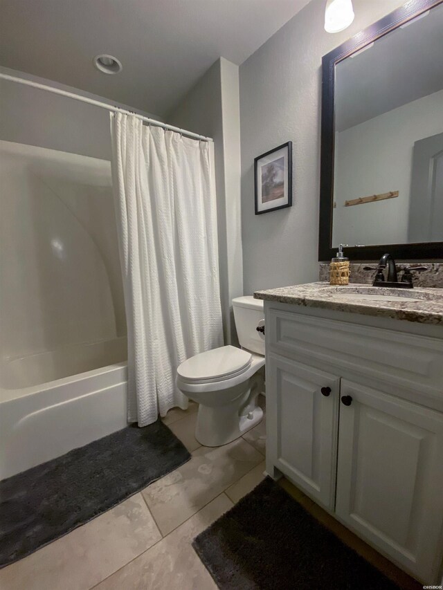 bathroom featuring toilet, tile patterned floors, vanity, and shower / tub combo with curtain