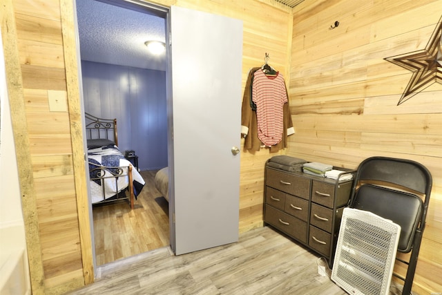 office area featuring wooden walls, light wood finished floors, and a textured ceiling