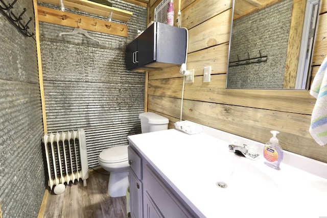 bathroom featuring radiator, vanity, toilet, and wood finished floors