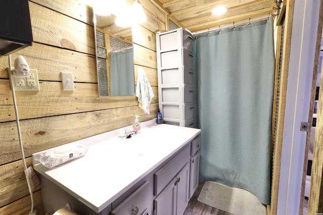 bathroom featuring wood walls, vanity, and a shower with shower curtain