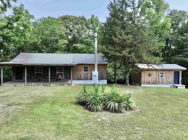 view of front of home with metal roof and a front lawn