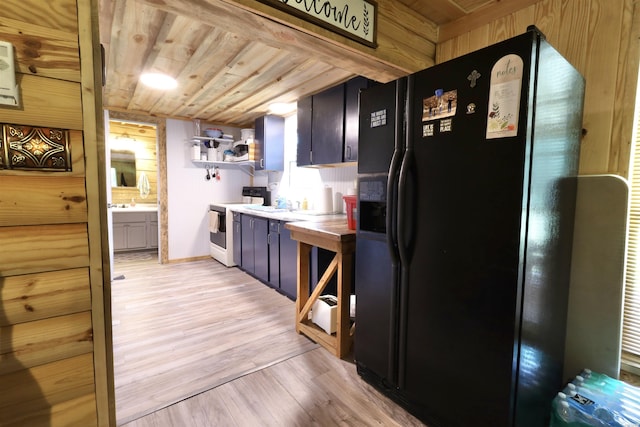 kitchen with white electric range oven, wooden ceiling, light wood-style flooring, light countertops, and black fridge