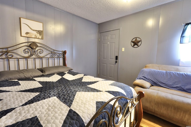 bedroom with light wood finished floors and a textured ceiling