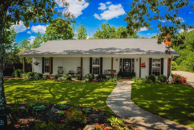 view of front of home featuring covered porch, a chimney, and a front yard