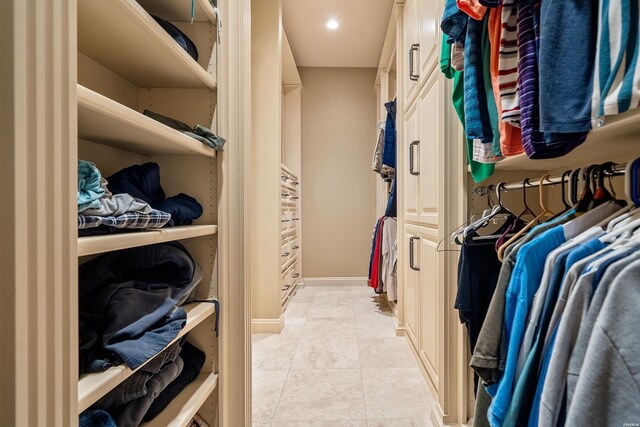 walk in closet with light tile patterned floors