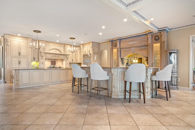 kitchen with pendant lighting, cream cabinets, glass insert cabinets, a kitchen island, and a chandelier