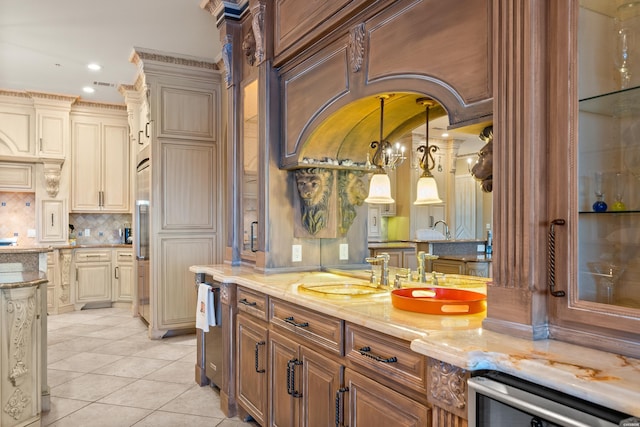 kitchen featuring light tile patterned floors, light stone counters, wine cooler, a sink, and hanging light fixtures