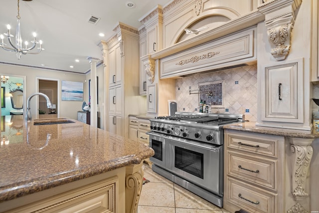 kitchen featuring stone counters, visible vents, pendant lighting, and range with two ovens