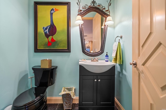 bathroom with toilet, vanity, baseboards, and tile patterned floors