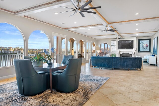 dining room featuring a fireplace, a ceiling fan, a wealth of natural light, and beamed ceiling