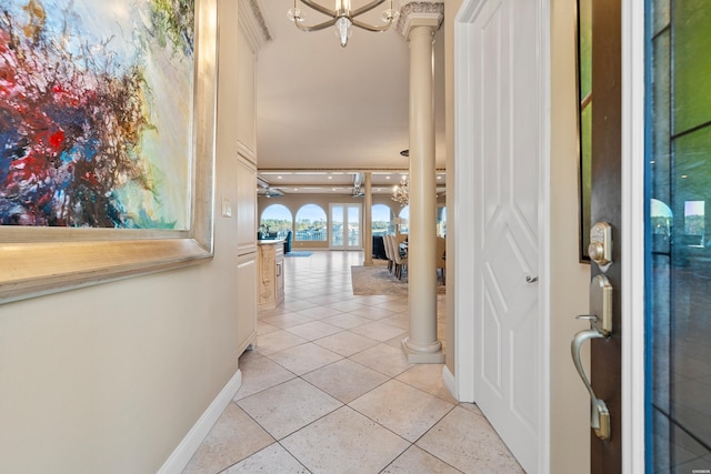 entrance foyer with ornate columns, light tile patterned floors, baseboards, and a notable chandelier