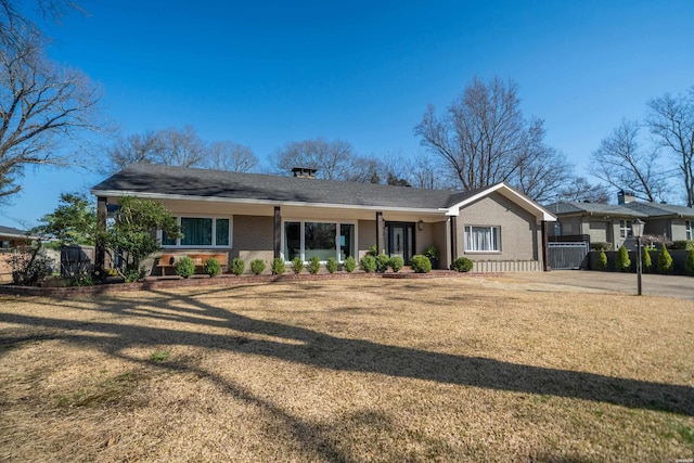 view of front facade featuring brick siding and a front yard