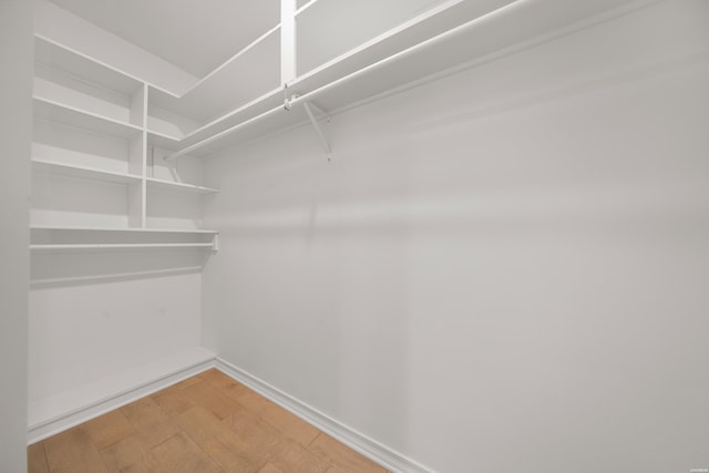 walk in closet with wood finished floors