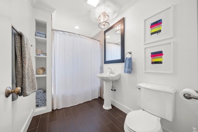 full bathroom featuring a shower with shower curtain, baseboards, wood tiled floor, a sink, and toilet