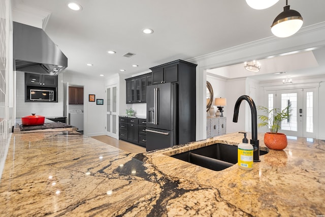 kitchen with a sink, ventilation hood, crown molding, light stone countertops, and high end refrigerator