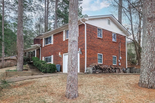 view of side of home with a garage and brick siding