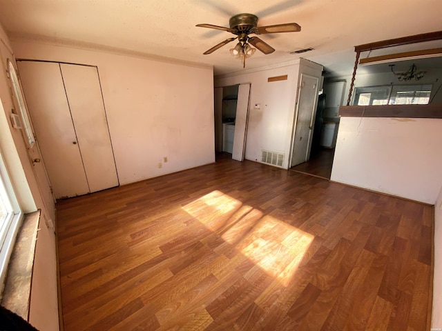 unfurnished bedroom with multiple closets, visible vents, and dark wood-style flooring