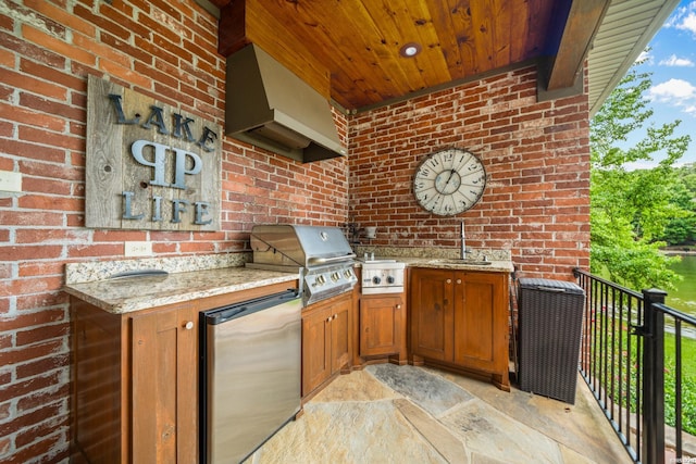 kitchen with brown cabinetry, wood ceiling, brick wall, custom range hood, and fridge