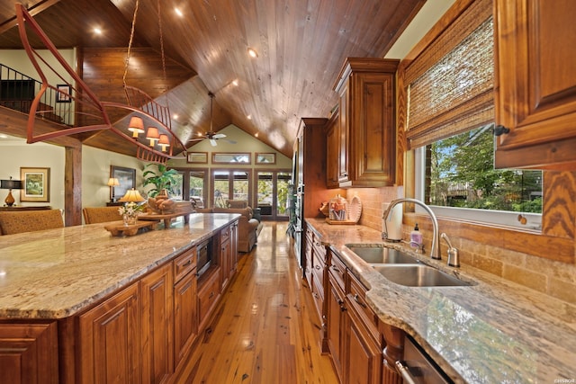 kitchen with open floor plan, stainless steel microwave, a sink, and wooden ceiling