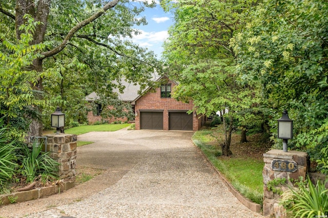 view of front facade featuring a garage, driveway, and brick siding