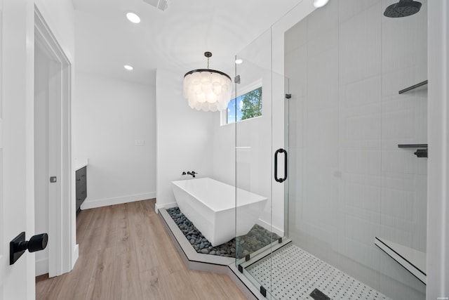 full bath featuring a freestanding bath, vanity, a shower stall, wood finished floors, and baseboards