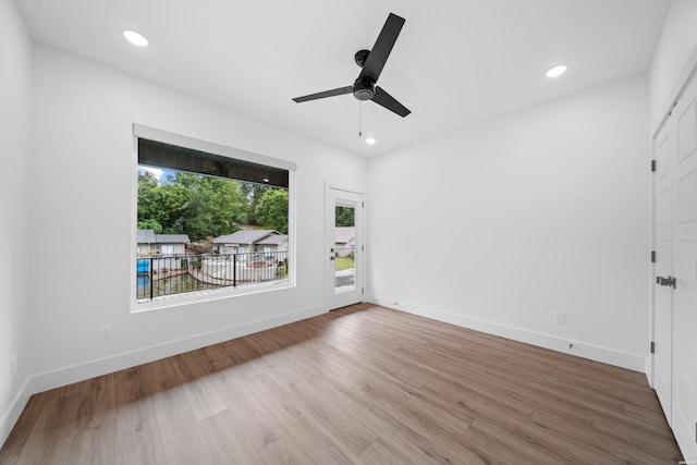 empty room featuring a ceiling fan, recessed lighting, baseboards, and wood finished floors