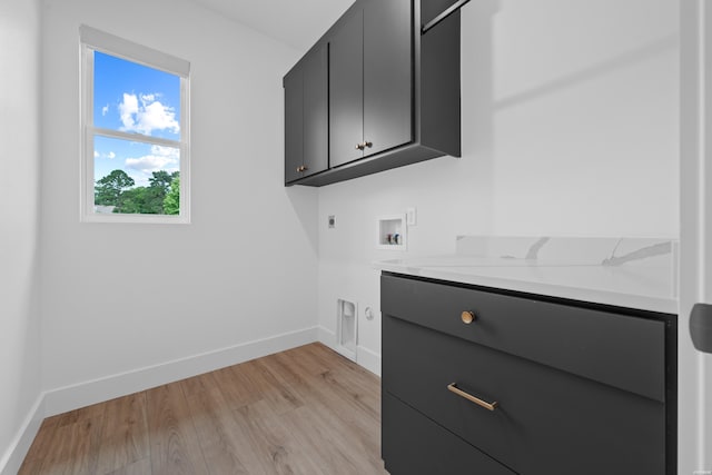 laundry area featuring hookup for a washing machine, light wood-style flooring, hookup for an electric dryer, baseboards, and cabinet space