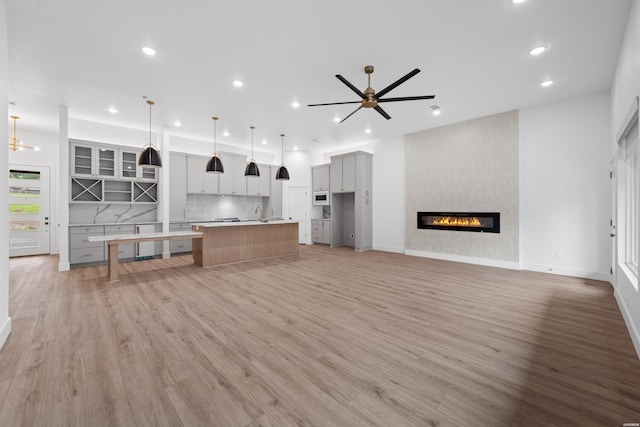 unfurnished living room with light wood-style floors, recessed lighting, and a large fireplace