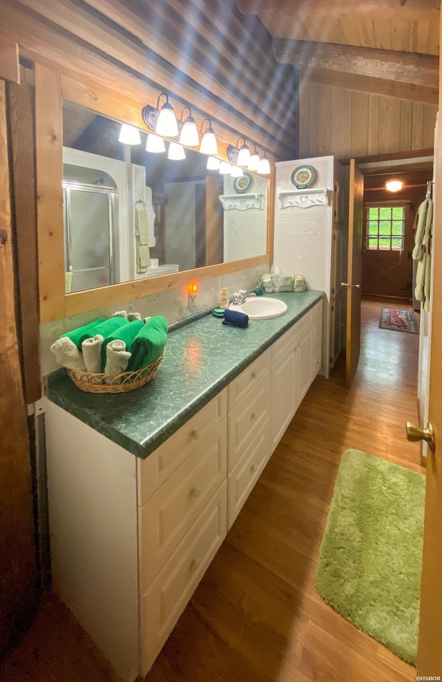 46 Hickory Hill Ln, Mount Ida, AR 71957 - bathroom with wood walls, wood finished floors, vanity, and vaulted ceiling
