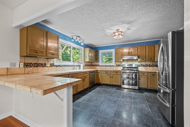 512 Beachview Cir, Hot Springs, AR 71913 - kitchen featuring appliances with stainless steel finishes, a peninsula, under cabinet range hood, decorative backsplash, and a textured ceiling
