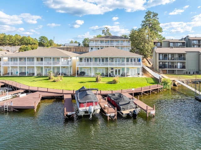 view of dock with a lawn, a water view, and boat lift