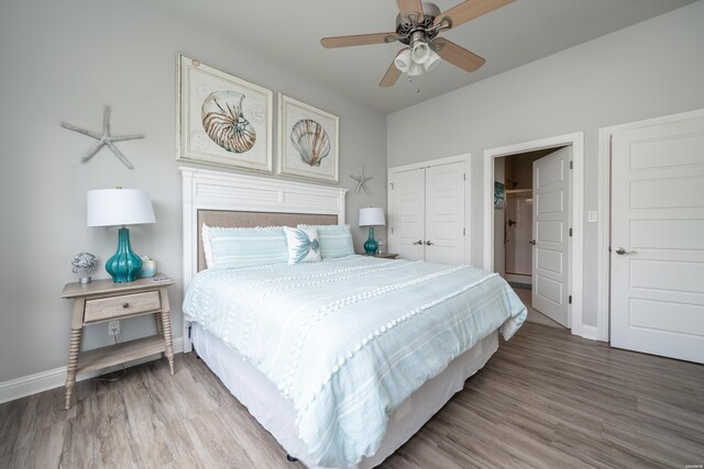 bedroom with ceiling fan, a closet, baseboards, and wood finished floors